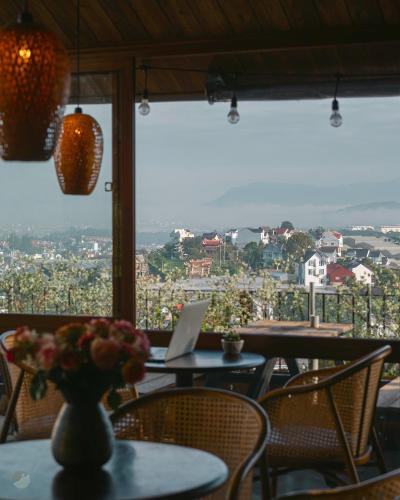 a table with a laptop on it in a restaurant at Miền Sương Khói - Home & Café in Khu Chi Lăng