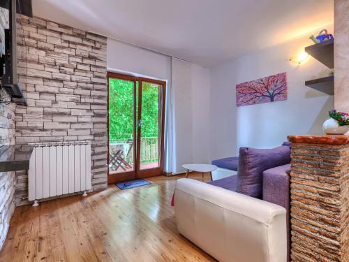 Una sala de estar con un sofá y una pared de ladrillos. en Apartment Apartmani Amaii-1 by Interhome, en Karigador