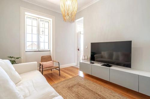 a white living room with a large flat screen tv at Villa Carvalhal in Funchal