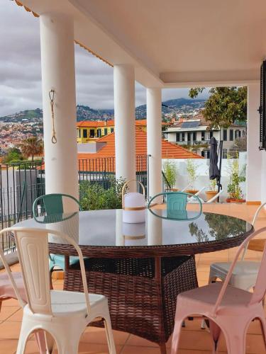 a patio with a glass table and chairs on a balcony at Villa Carvalhal in Funchal