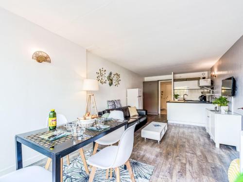 a kitchen and living room with a dining table and chairs at Apartment Les Marines-10 by Interhome in La Foux
