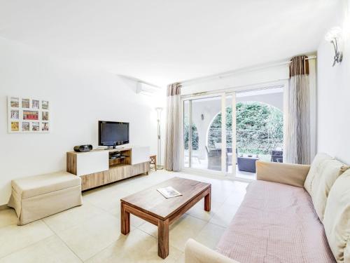 a living room with a couch and a table at Apartment Le Jardin d'Artemis-1 by Interhome in Saint-Tropez