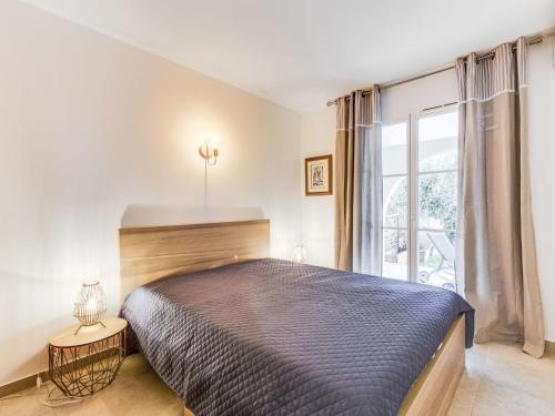a bedroom with a large bed and a window at Apartment Le Jardin d'Artemis-1 by Interhome in Saint-Tropez