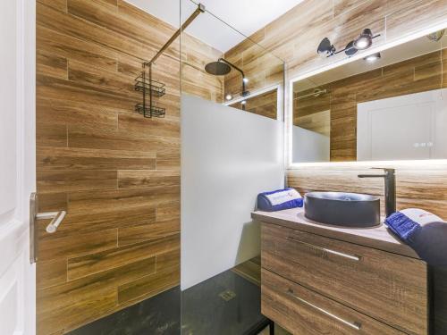 La salle de bains est pourvue de murs en bois et d'un lavabo. dans l'établissement Apartment Le Jardin d'Artemis-1 by Interhome, à Saint-Tropez