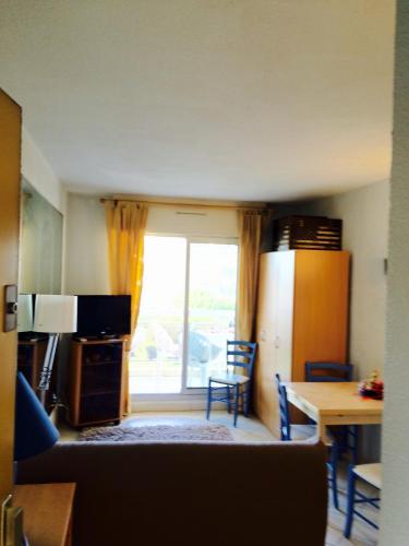 un salon avec une table et une fenêtre dans l'établissement Appartment Plein Soleil, au Golfe-Juan