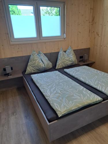 a large bed in a room with two windows at Ferienhaus und Ferienappartements Brunner in Höchst