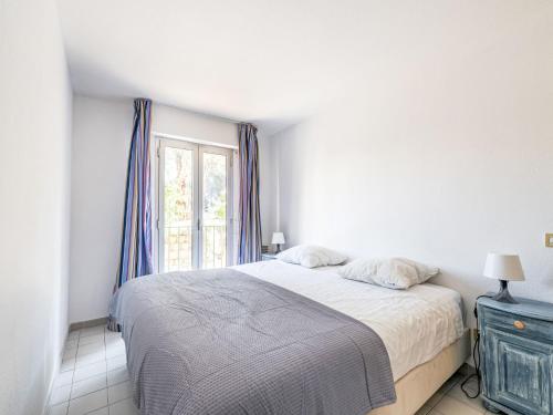 une chambre blanche avec un lit et une fenêtre dans l'établissement Apartment Caesar Domus-7 by Interhome, à Saint-Tropez