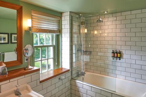 a bathroom with a tub and a sink and a mirror at Hotel Du Vin & Bistro York in York