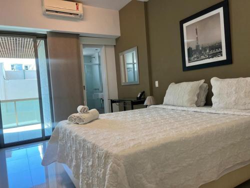 a bedroom with a large white bed with a window at Lindo FLAT no coração de Ipanema in Rio de Janeiro