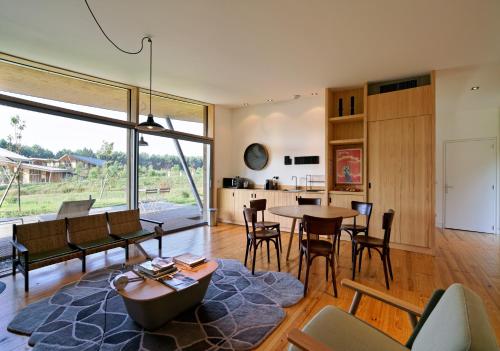 un salon avec une table et des chaises et une cuisine dans l'établissement Les Échasses Golf & Surf Eco Lodge, à Saubion