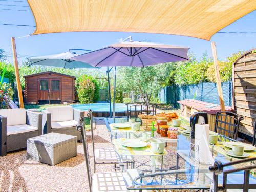 un patio avec une table et un parasol dans l'établissement Holiday Home Villa Les Genêts by Interhome, à Montauroux