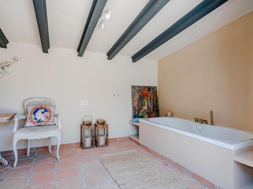 a large bathroom with a tub and a chair at Villa Charme by Interhome in Jávea