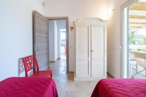 a bedroom with two beds and a door to a balcony at Agrivillage San Lorenzo in San Lorenzo