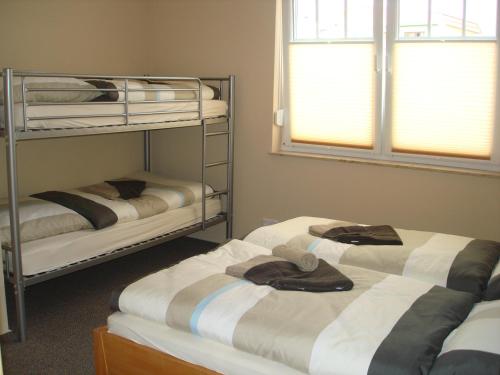 ein Zimmer mit 3 Etagenbetten mit Handtüchern darauf in der Unterkunft Zinnowitz-Ambiente in Zinnowitz