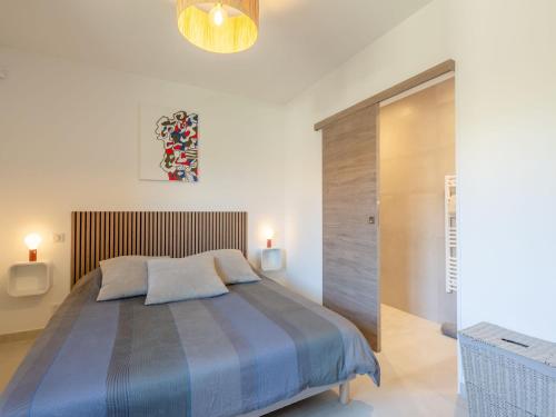 une chambre avec un grand lit avec une tête de lit en bois dans l'établissement Holiday Home Akemi by Interhome, à Sainte-Maxime