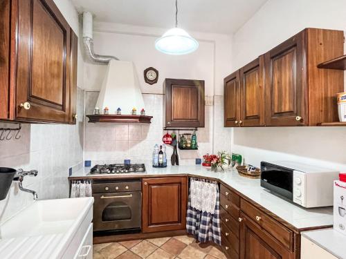 a kitchen with wooden cabinets and a stove top oven at Holiday Home Lidia by Interhome in Pianavia