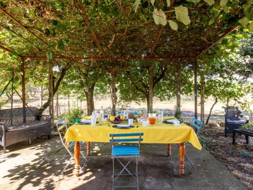 a yellow table with chairs under a tree at Holiday Home Podere Cavaceppi by Interhome in Pitigliano