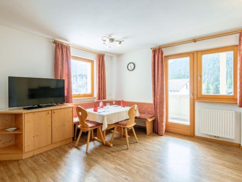 a living room with a dining room table and a television at Apartment Nr- 7 by Interhome in Solda