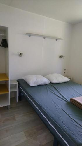 un lit dans une chambre avec deux oreillers dessus dans l'établissement 45mn de Paris - Beau mobilhome pour famille et travail, à Saint-Chéron