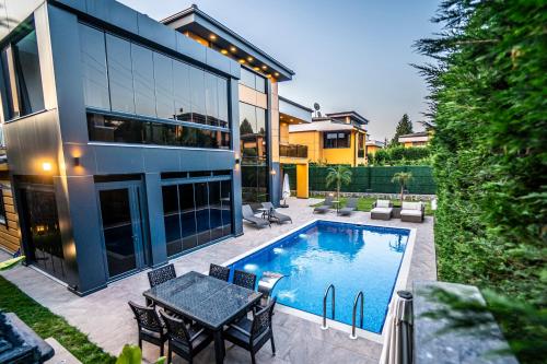 a house with a swimming pool and a table and chairs at Yakut Mansion Sapanca in Sapanca