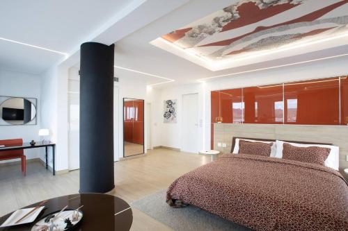 a bedroom with a bed and a table and a ceiling at Serenity Penthouse - The Pinnacle of Luxury in Maho Reef