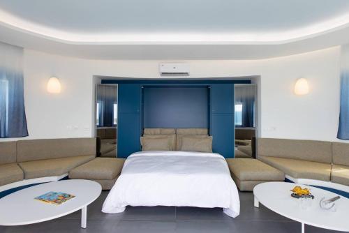 a bedroom with a bed and two tables at Serenity Penthouse - The Pinnacle of Luxury in Maho Reef