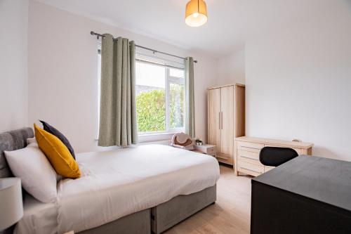 un dormitorio con una cama y una ventana en LARGE Modern House, Sleeps 17 with Parking, en Galway