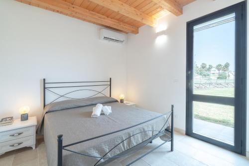 a bedroom with a bed and a large window at Agrivillage San Lorenzo in San Lorenzo