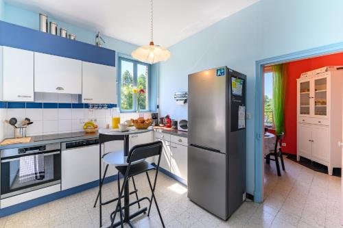 Il comprend une cuisine équipée d'un réfrigérateur, d'une table et de chaises. dans l'établissement L’Éclusière - Charmante maison éclusière, à Guise