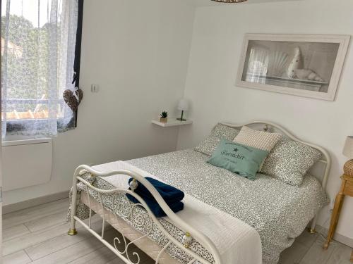 a white bedroom with a bed and a window at Chambre d'hôtes près de la plage in Pornichet