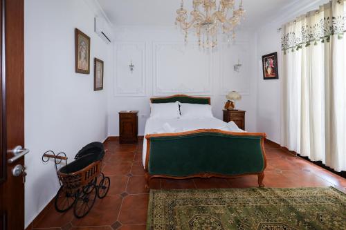 a bedroom with a bed and a chandelier at Sunrise House - Swimming Pool in Berat