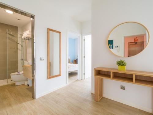 ein Badezimmer mit einem Spiegel, einem Waschbecken und einem WC in der Unterkunft VIVENTE - Viviendas Vacacionales in Guanarteme