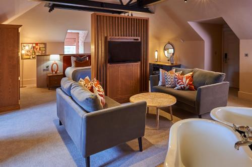 a living room with a tv and a couch and a table at Hotel Du Vin & Bistro York in York