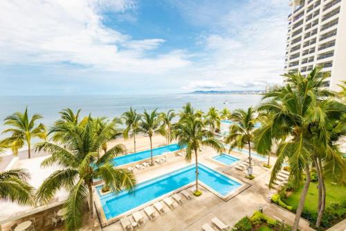 an aerial view of a resort with palm trees and the ocean at Harbor 5002 by Moikkarentals in Puerto Vallarta