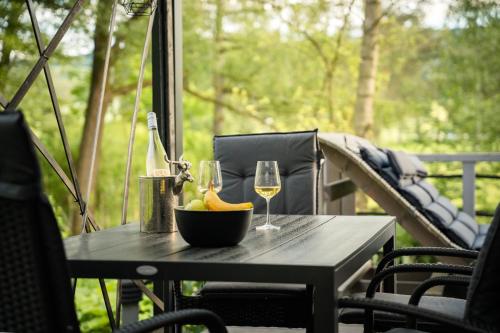 a table with a bowl of fruit and a glass of wine at Sea Side, Tiny House 13 in Salzhemmendorf