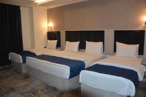 a hotel room with three beds in a room at MyFlower 3 Hotel in Erbil