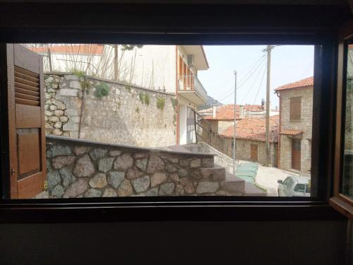 ein Blick aus einem Fenster auf eine Steinmauer und Treppen in der Unterkunft Arachova Cozy in Arachova