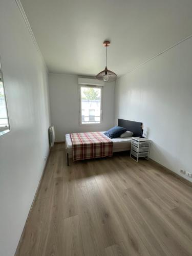une chambre avec un lit et un parquet dans l'établissement Appartement avec vue sur le Stade de France & le canal, à Saint-Denis