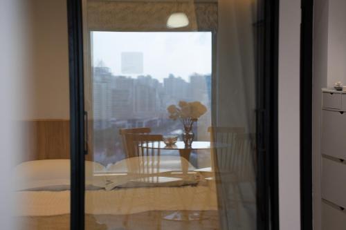 a dining room with a table and a window at Shanghai Yi Du B&B - Near Nanjing West Road commercial district, 350 walk from the Natural History Museum subway in Shanghai