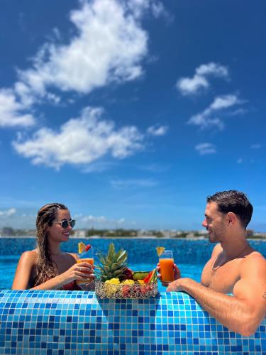 a man and woman sitting at a table in the water at Balkon Boutique Hotel in Playa del Carmen