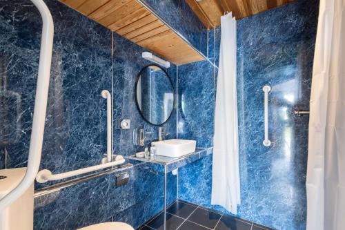 a blue bathroom with a sink and a mirror at Host & Stay - Crackin' View in Hexham