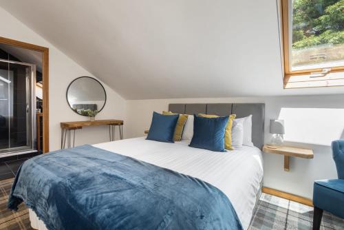 a bedroom with a large bed with blue pillows at Host & Stay - Crackin' View in Hexham