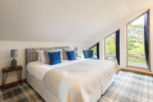 a bedroom with a large white bed with blue pillows at Host & Stay - Crackin' View in Hexham