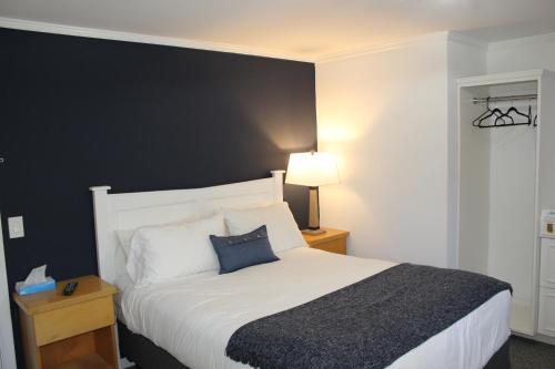 a bedroom with a bed with a black accent wall at Catskill Seasons Inn in Shandaken