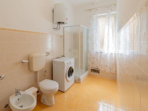 a bathroom with a toilet and a washing machine at Casa Vacanze Ginevra in Mandra Capreria