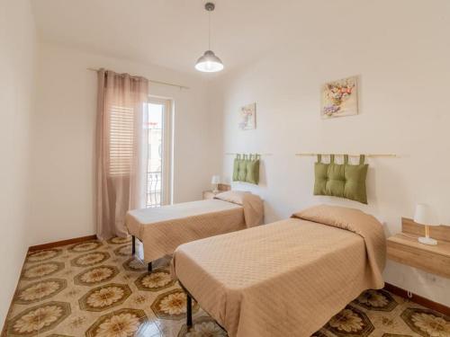 a room with two beds and a window at Casa Vacanze Ginevra in Mandra Capreria