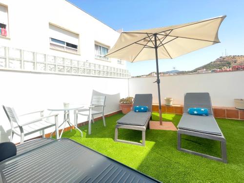 a patio with a table and chairs and an umbrella at MalagadeVacaciones - Atico victoria in Málaga