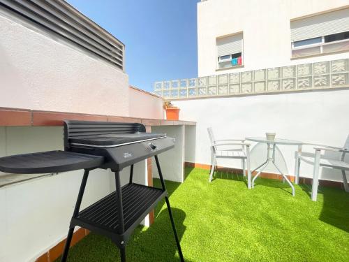 a barbecue grill on a balcony with green grass at MalagadeVacaciones - Atico victoria in Málaga