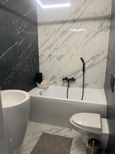 a bathroom with a white tub and a toilet and a sink at Apartament led w pobliżu Zakopanego ! in Nowy Targ