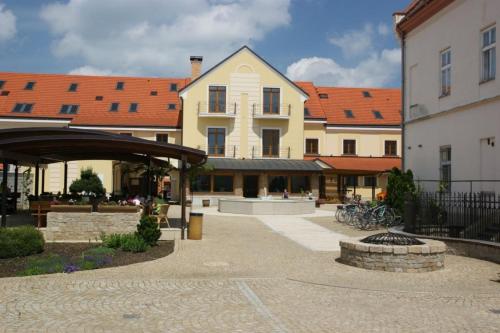 a large building with a courtyard in front of it at Hotel Mario in Lednice